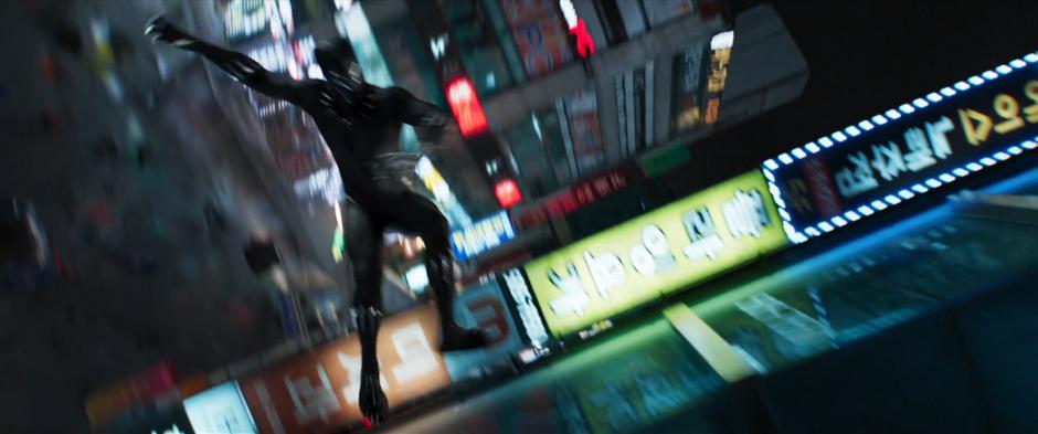 T'Challa runs along the side of a building.