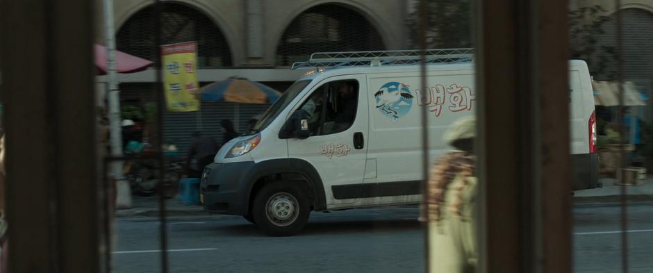A suspicious van drives past the front of the safe house.