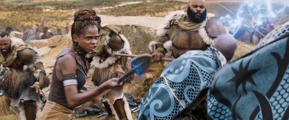 Shuri fights with a spear in the middle of a group of Jabari.