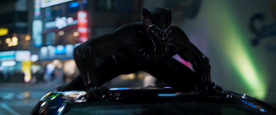 T'Challa crouches low on top of the car.