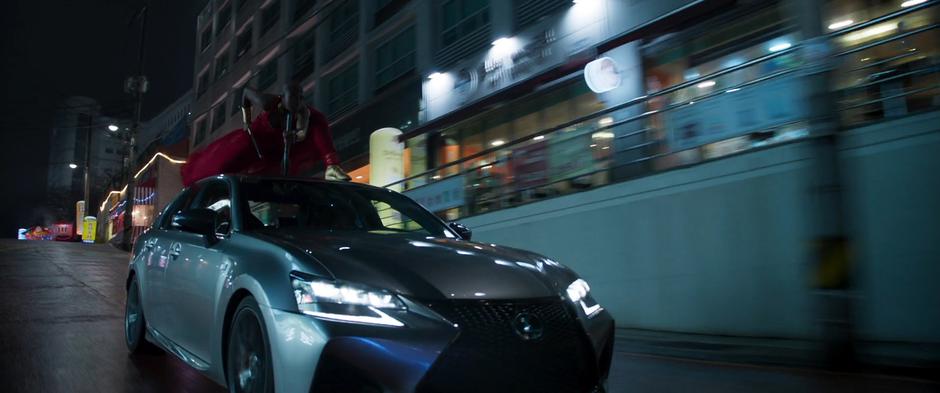 Okoye rides on top of the car while Nakia drives.