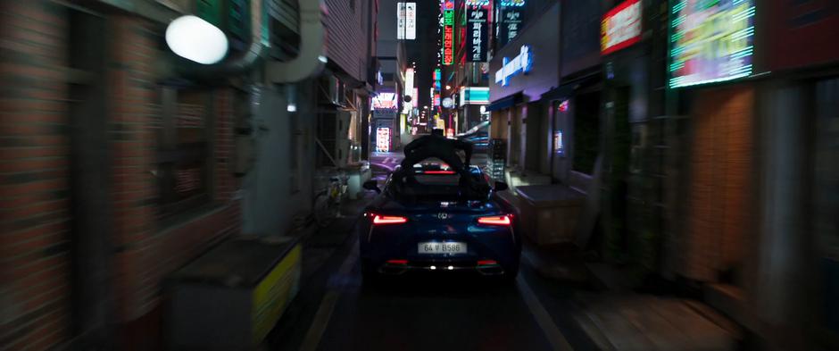 T'Challa rides atop the Shuri-controlled car as it races towards an intersection.