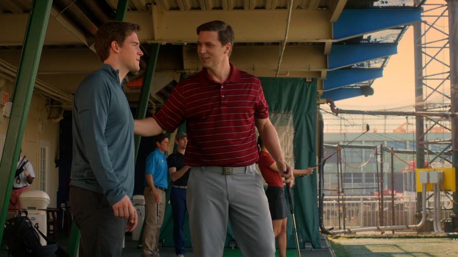 Troy Dickerson's puts a hand on his shoulder in the driving range.