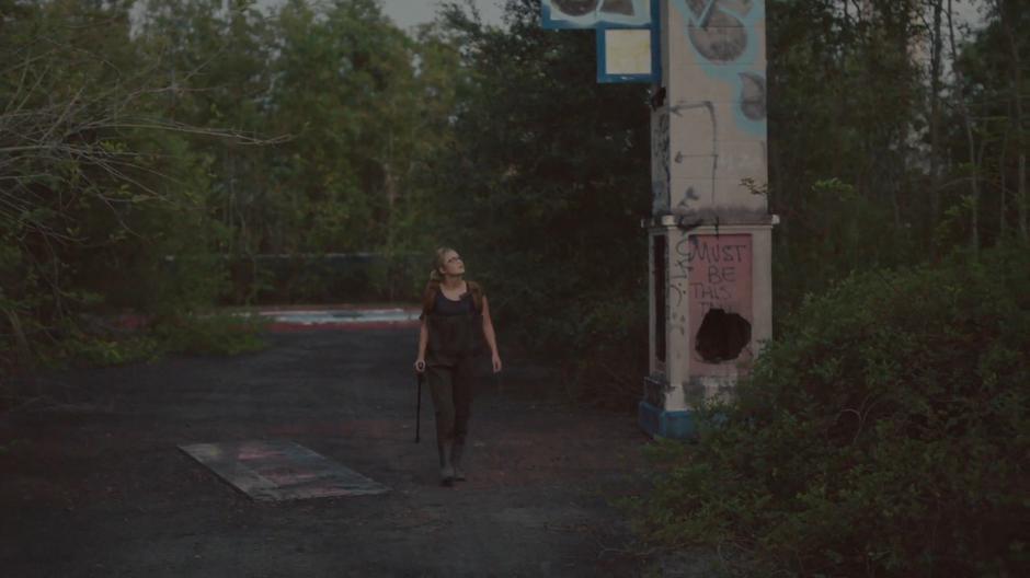 Tandy looks up at the abandoned rides while heading to Mina Hess's home.