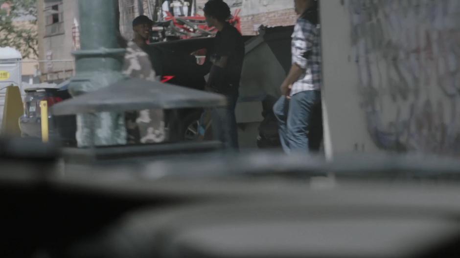 The dealer is visible talking to some folks through the windshield of O'Reilly's car.