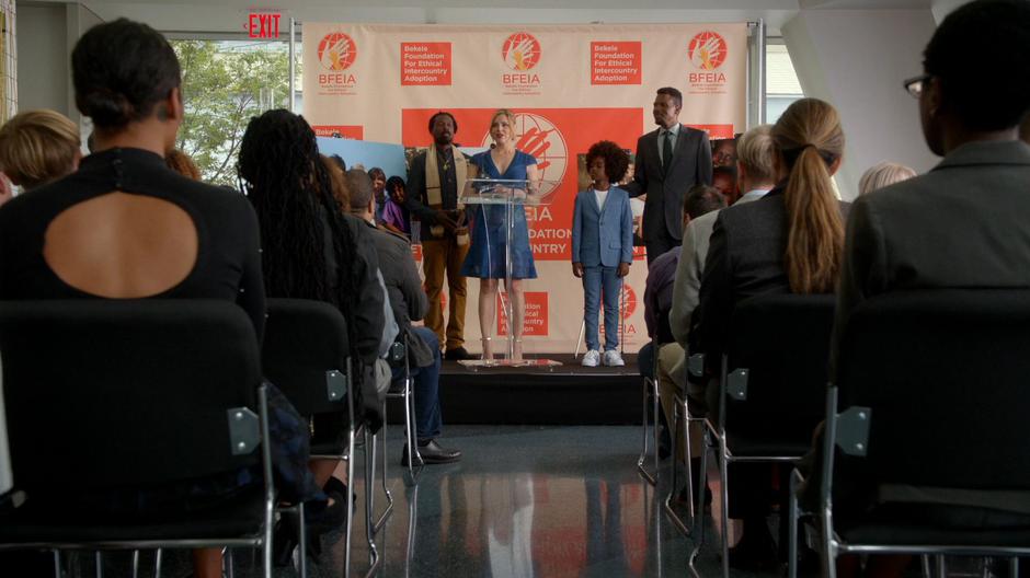 Amaya Andrews addresses the gathered reporters with Abel Bekele and Alexander on stage with her.