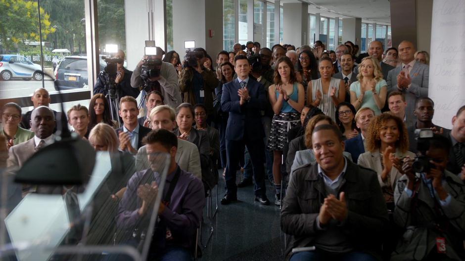 Everyone claps while the reporters film at the end of the press conference.