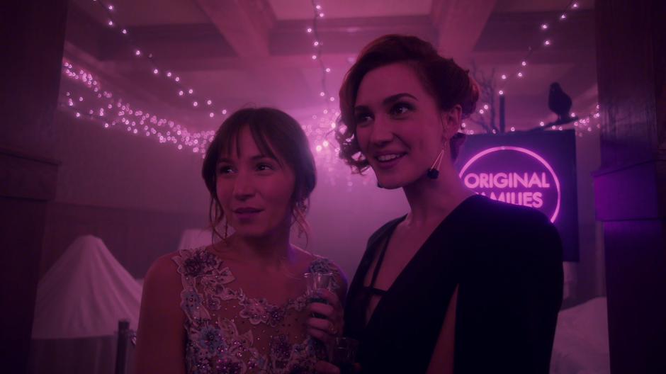 Waverly and Nicole stand close while commenting on the vampire party.