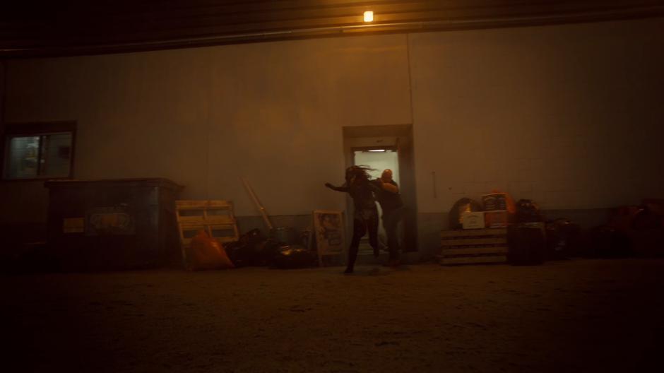 A bouncer throws Wynonna out of the bar into the back alley.