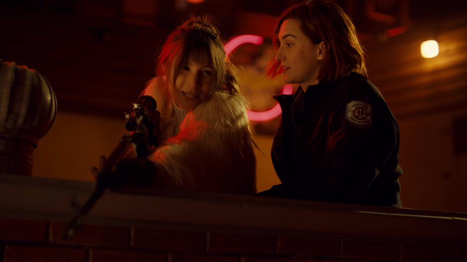 Waverly and Nicole chat cutely on the roof while Waverly holds a rifle down at the back alley behind the bar.