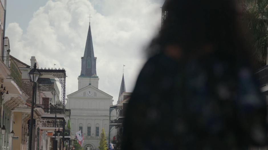 Auntie Chantelle walks down the middle of the street with the church looming in the background.