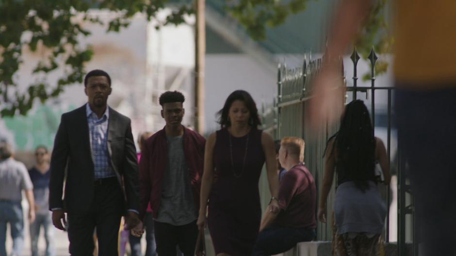 Tyrone follows his parents down the street to their car.