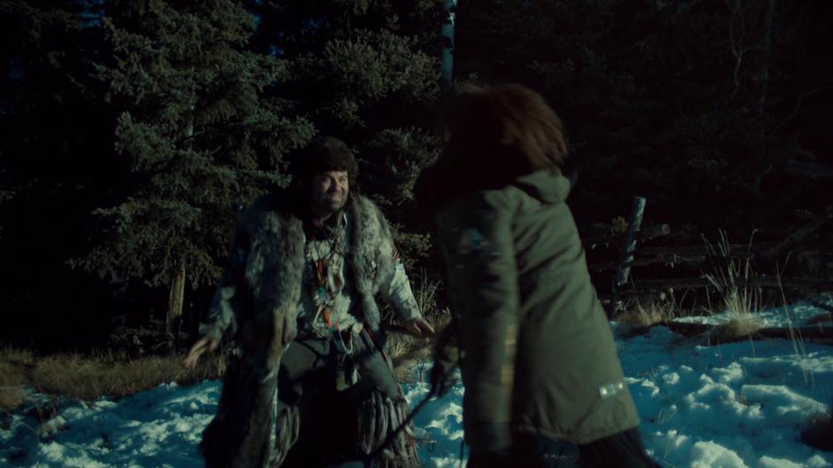 Wynonna swings her tire iron at the Revenant by the edge of the woods.