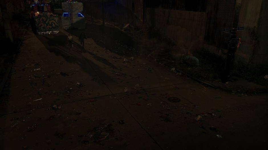 Tandy and Tyrone run down the dark street past several abanonded Mardi Gras floats.