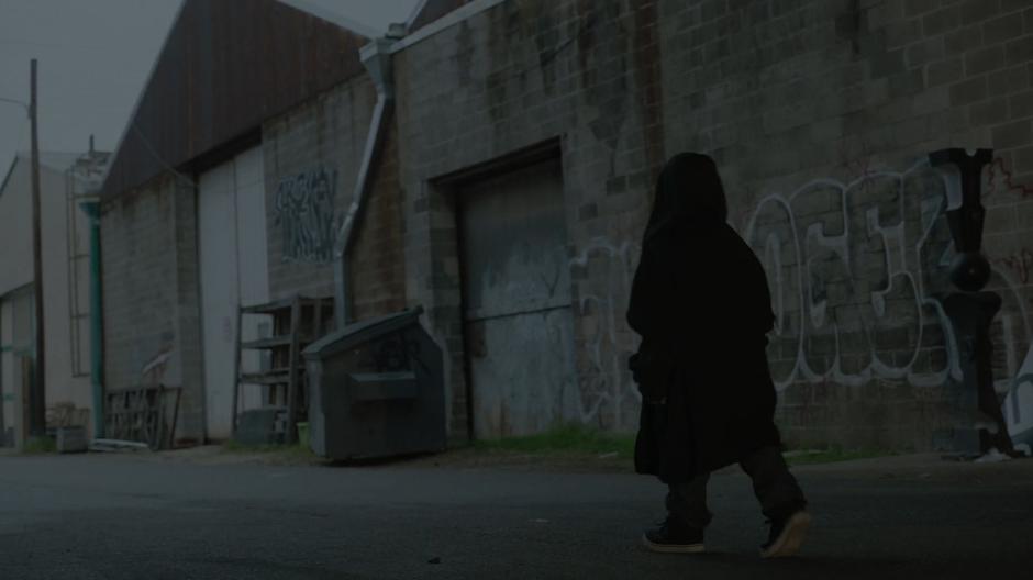 Young Tyrone walks down the street in his brother's hoodie.