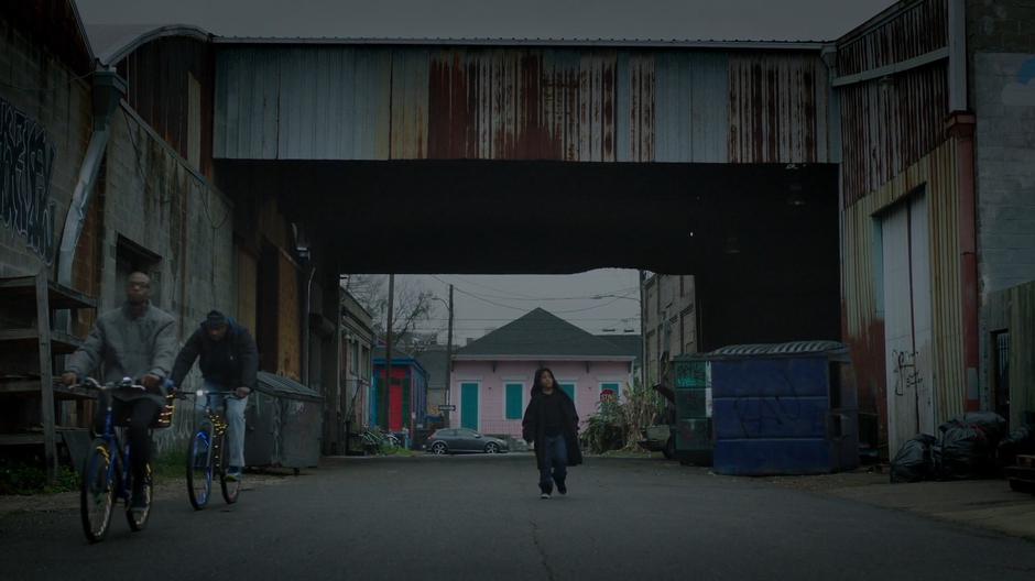 Young Tyrone walks down the street in Billy's huge hoodie while two other people ride past on bikes.