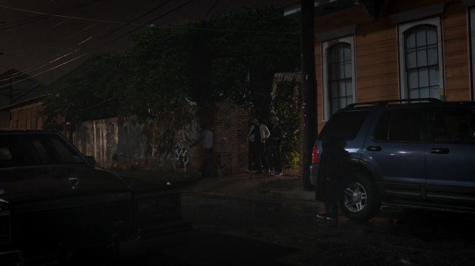 Young Tyrone watches from behind a car while Billy walks away after refusing to help his friends steal back the radio.