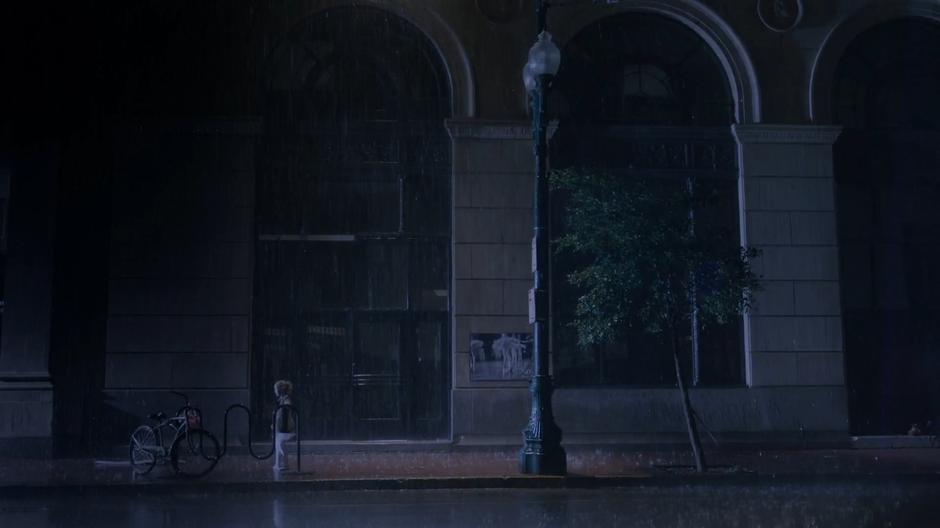 Tandy dances in the rain on the sidewalk late at night while waiting for her father.