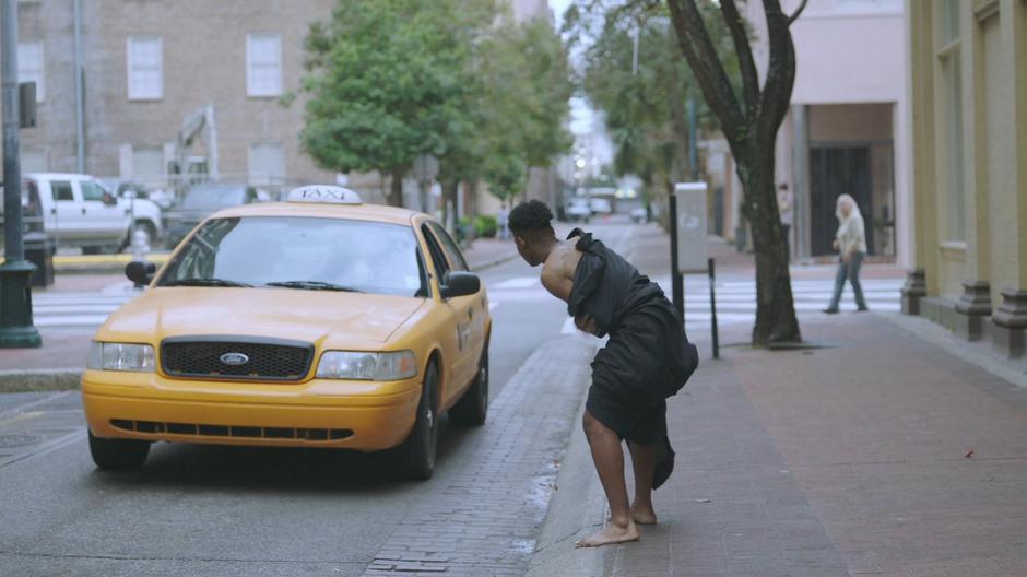 Tyrone leans over to a taxi to try to get a ride back home.