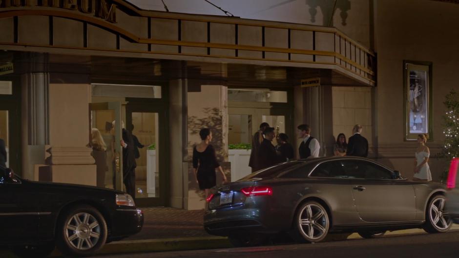 Tandy walks down the sidewalk to the front of the theater as others arrive.