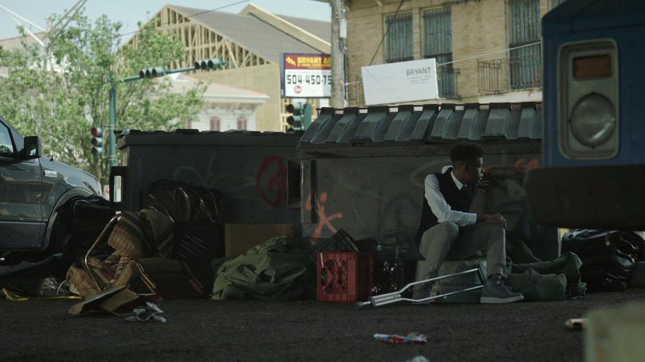 Tyrone sits down on a pile of junk and waits for Connors to arrive home.