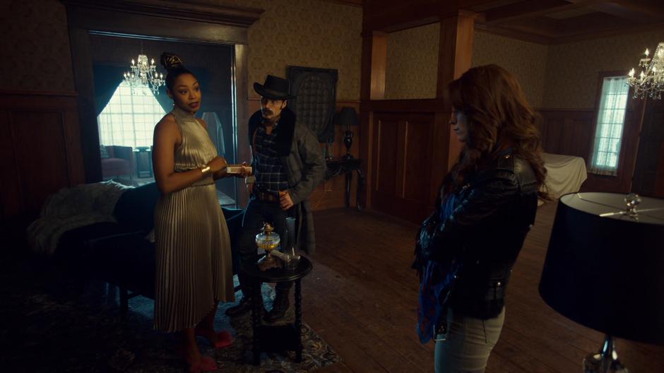 Kate talks to Doc and Wynonna while lighting a gas lamp.