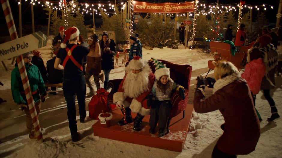 Nedley gets his photo taken with a kid while dressed as Santa.