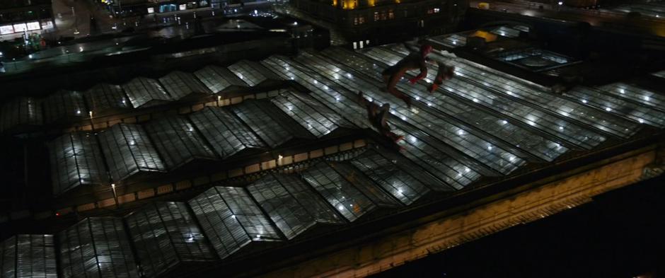 Wanda and Vision fly through the air towards the glass roof of the train station.