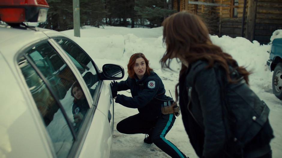 Nicole looks up at Wynonna while reaching for her backup key.