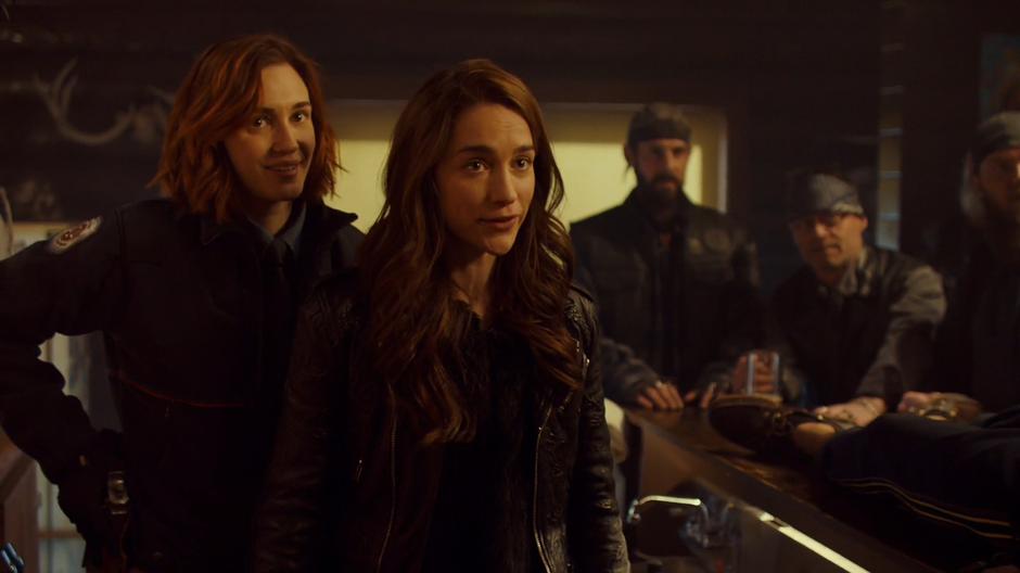 Nicole and Wynonna nervously smile while being surrounded by Revenants.