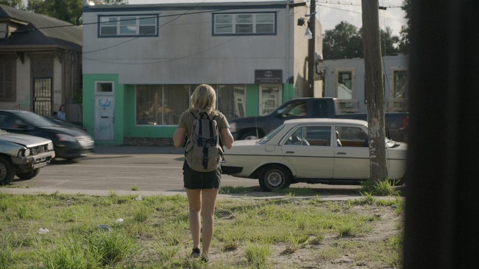 Tandy walks across the grass toward's Greg's law office.