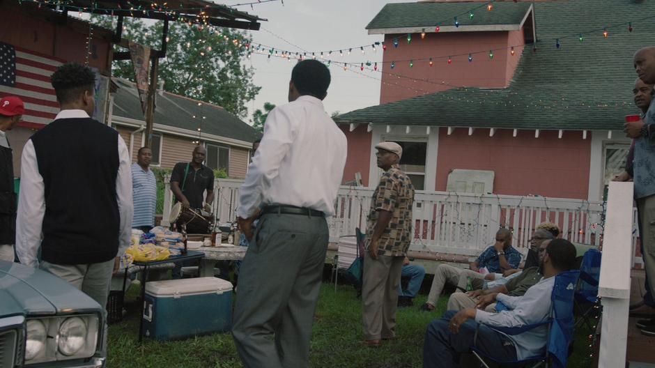 A bunch of people turn to watch as Tyrone and Otis enter the yard.