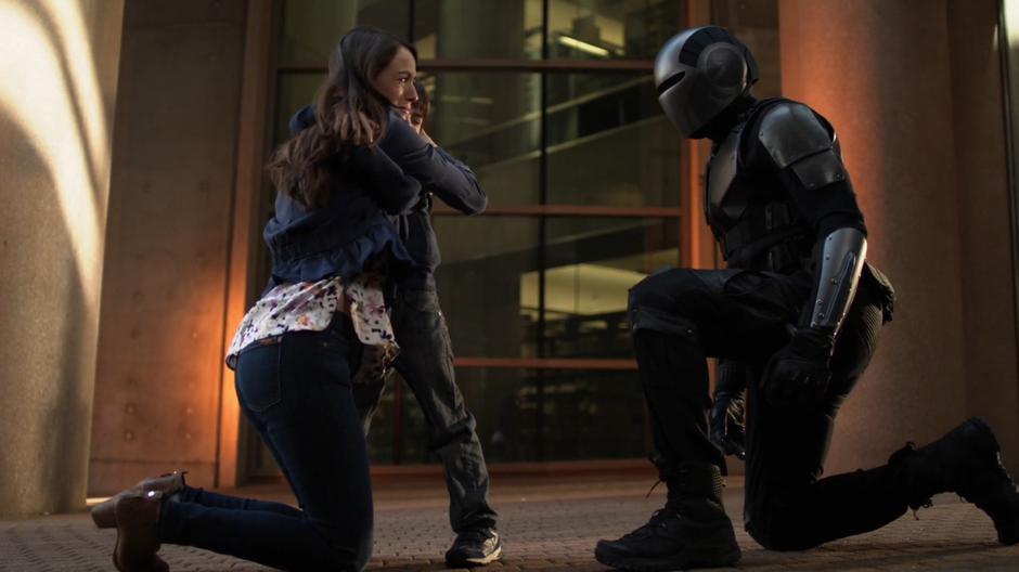 James kneels down in front of the woman and her child that he rescued.