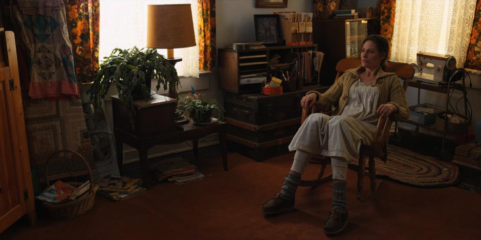 Terry Ives sits in her rocking chair staring at the TV.