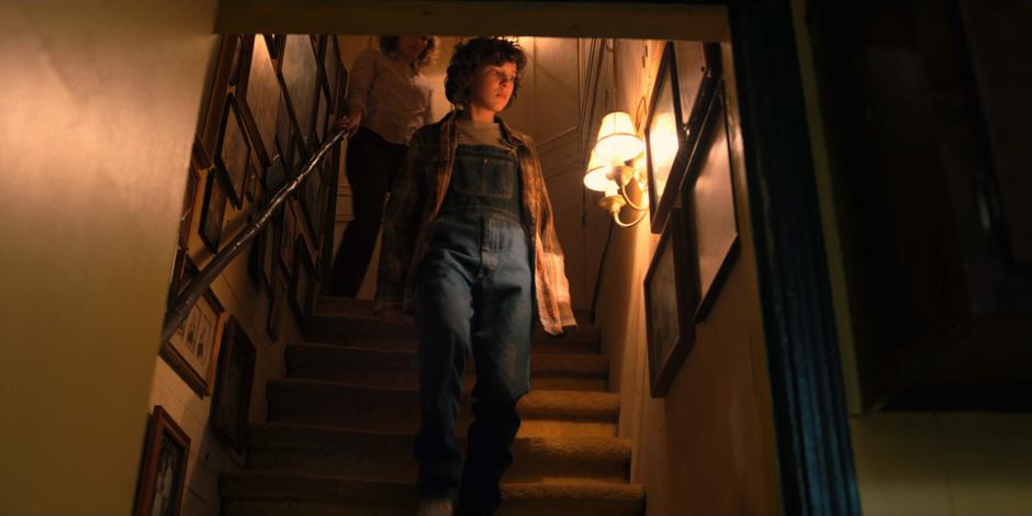 Eleven follows the flashing lights down the stairs with Becky Ives.