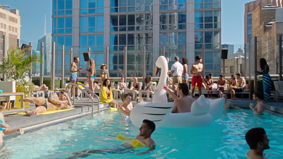 Liza stands in the pool with a giant floating swan.