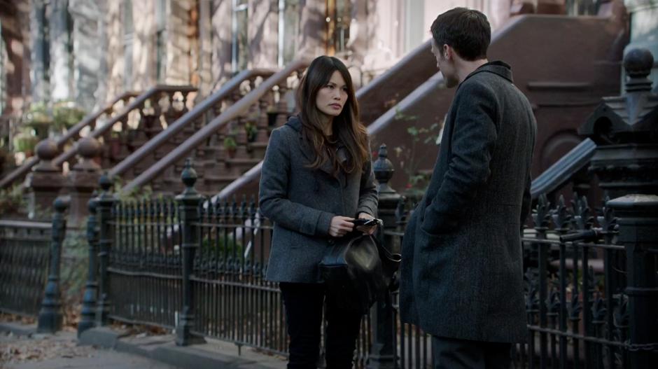 Agent Bouchard talks to Kelli Lin on the sidewalk outside her apartment.