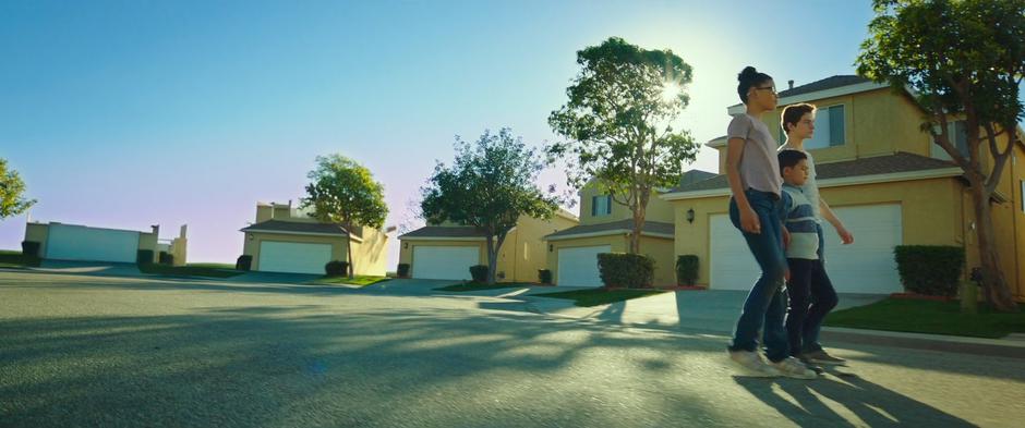 Meg, Charles Wallace, and Calvin walk down the street as the neighborhood disintegrates around them.