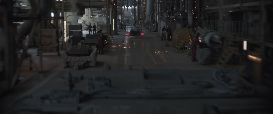 Lady Proxima's goons follow the speeder through the middle of a factory floor.