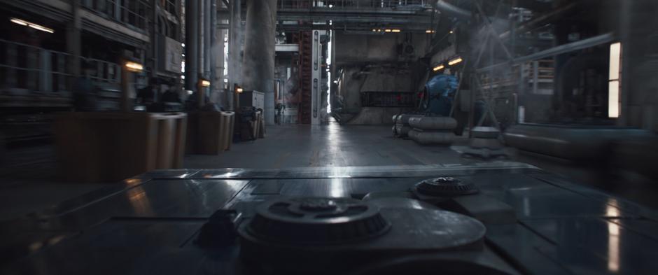 Qi'ra & Han's speed races at a narrow gap between two pieces of equipment.