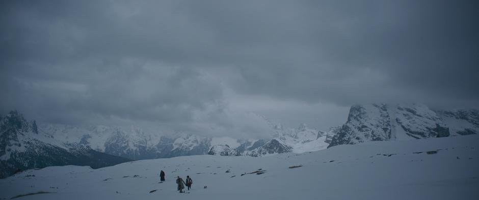 Han, Beckett, and Val trudge across the snow back to their camp.