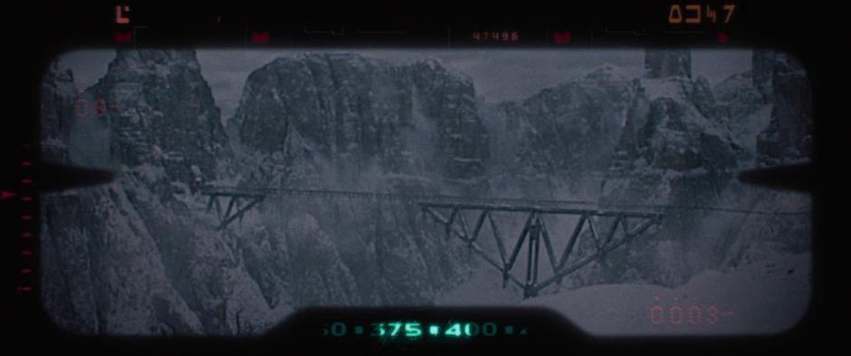 The bridge that the team plans on destroying is visible through their binoculars.