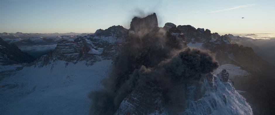 The crew's ship flies off as a mountain collapses after an explosion.