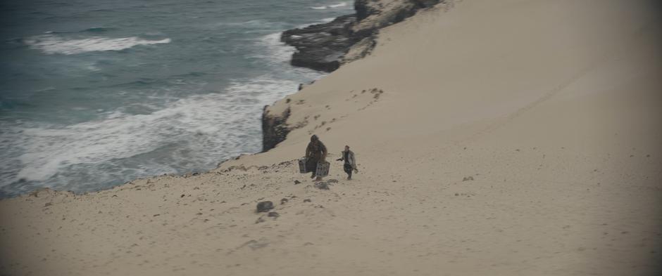 Beckett forces Chewie to walk along the top of the cliff with the cases of coaxium.