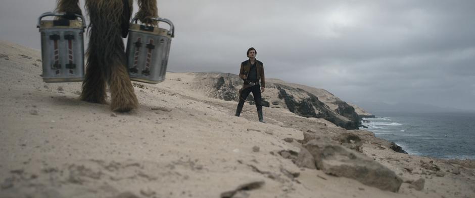 Chewie walks off to the side while Han stands in the path with his blaster trained on Beckett.