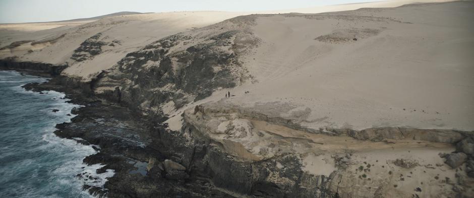 Han and Chewie walk over to the edge of the cliff past Beckett's body.