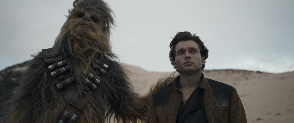 Chewbacca puts his hand on Han's shoulder as they watch Qi'ra fly off in Dryden Vos's ship.