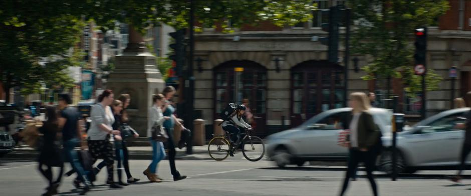 Lara rides her bike down the busy street.