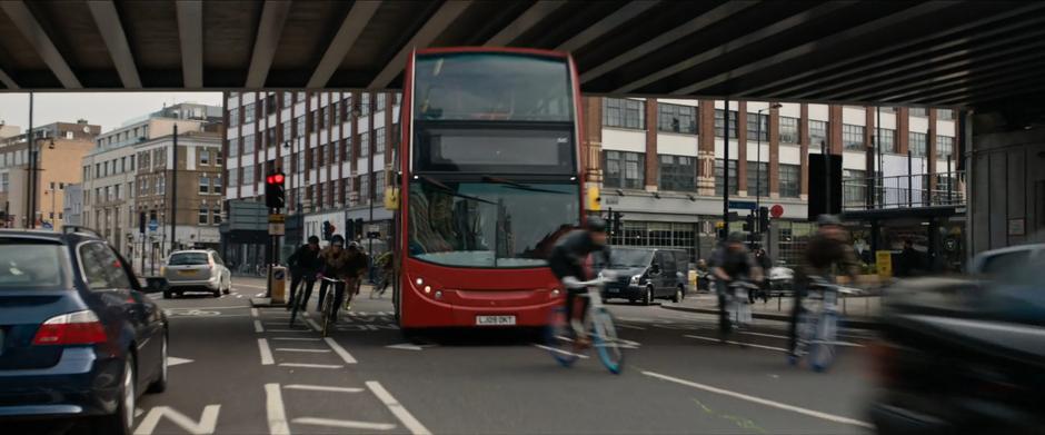 The people chasing Lara bike around the bus and follow her under the bridge.