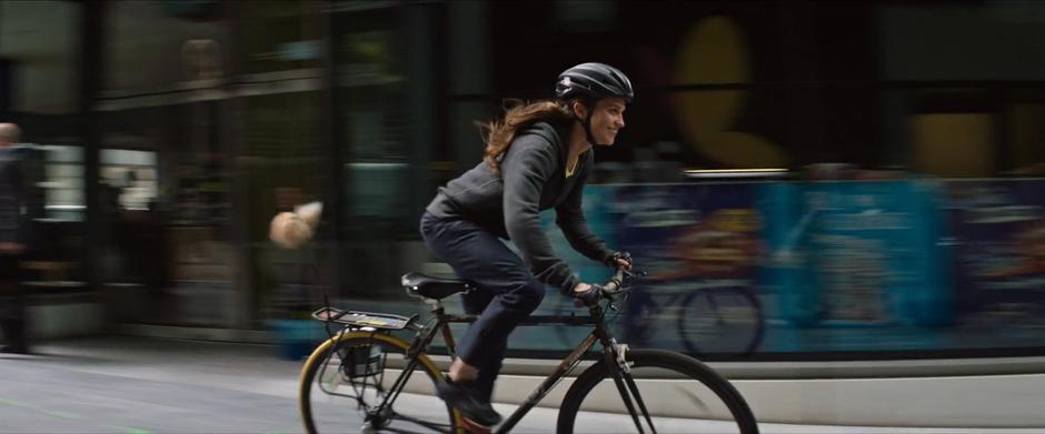 Lara smiles as she rides through the square.